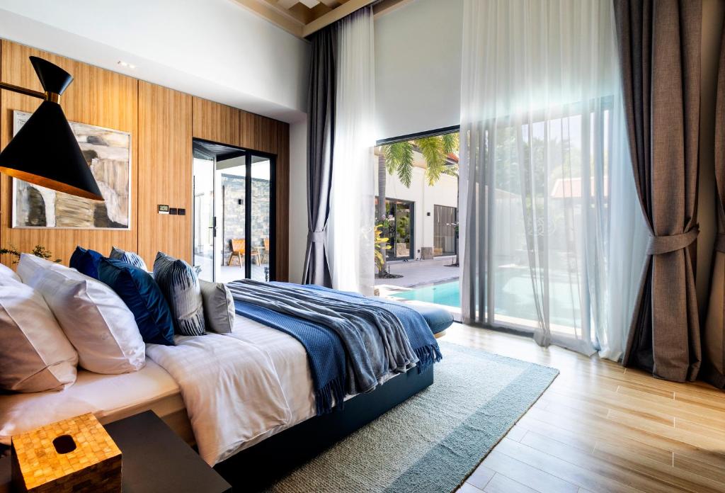 a bedroom with a large bed and a large window at Luxury 4 Bedroom Villa 1 Minute from Laguna Phuket in Bang Tao Beach