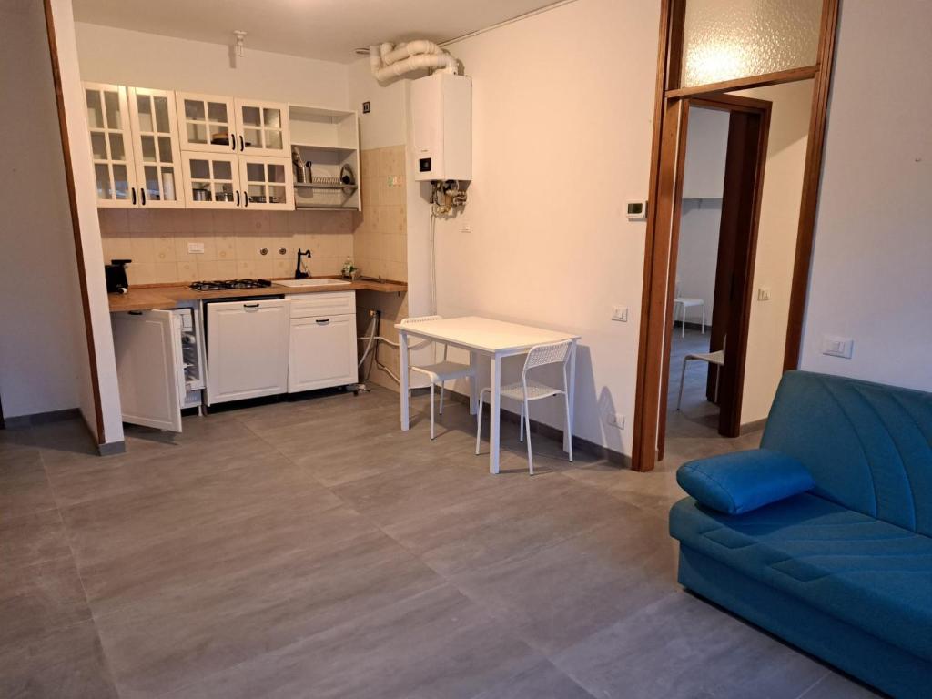 Il comprend une cuisine et un salon avec une table et un canapé bleu. dans l'établissement Casa Mare Massa Pinete, à Marina di Massa