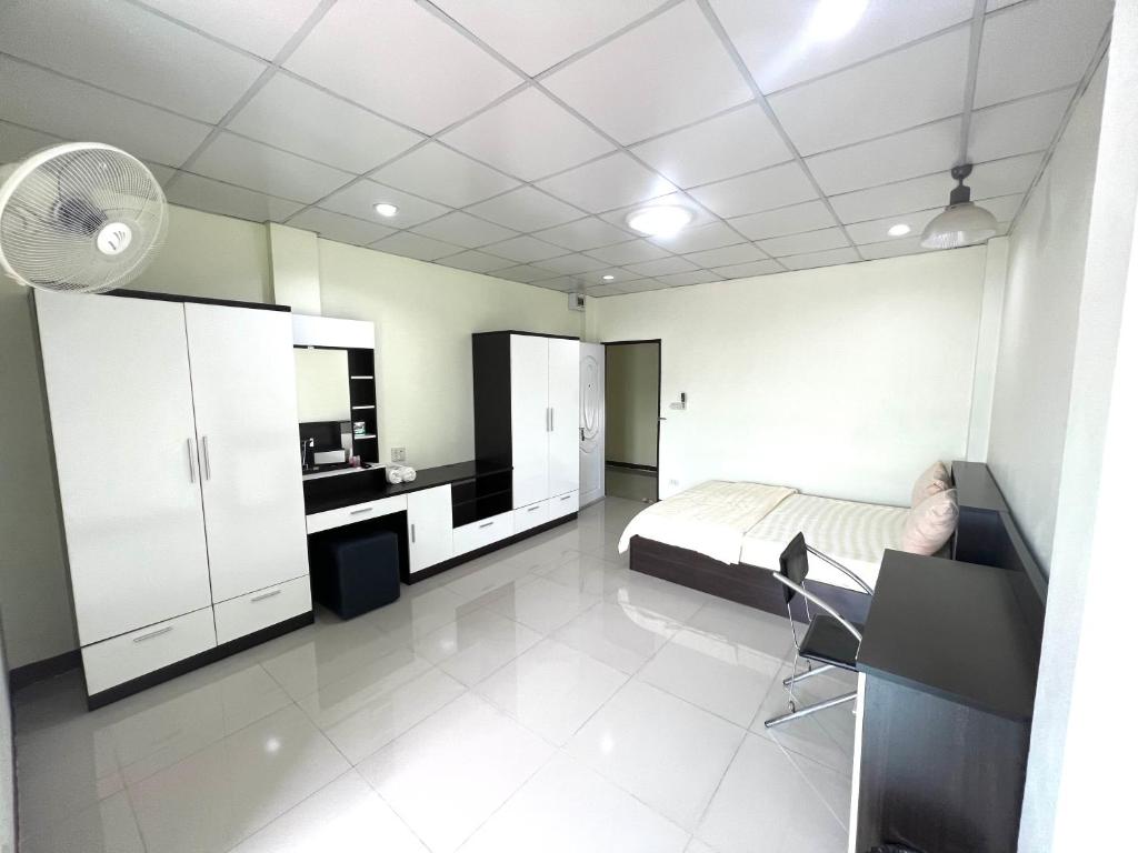 een slaapkamer met een bed, een bureau en een wastafel bij Jaroon House in Samutprakarn