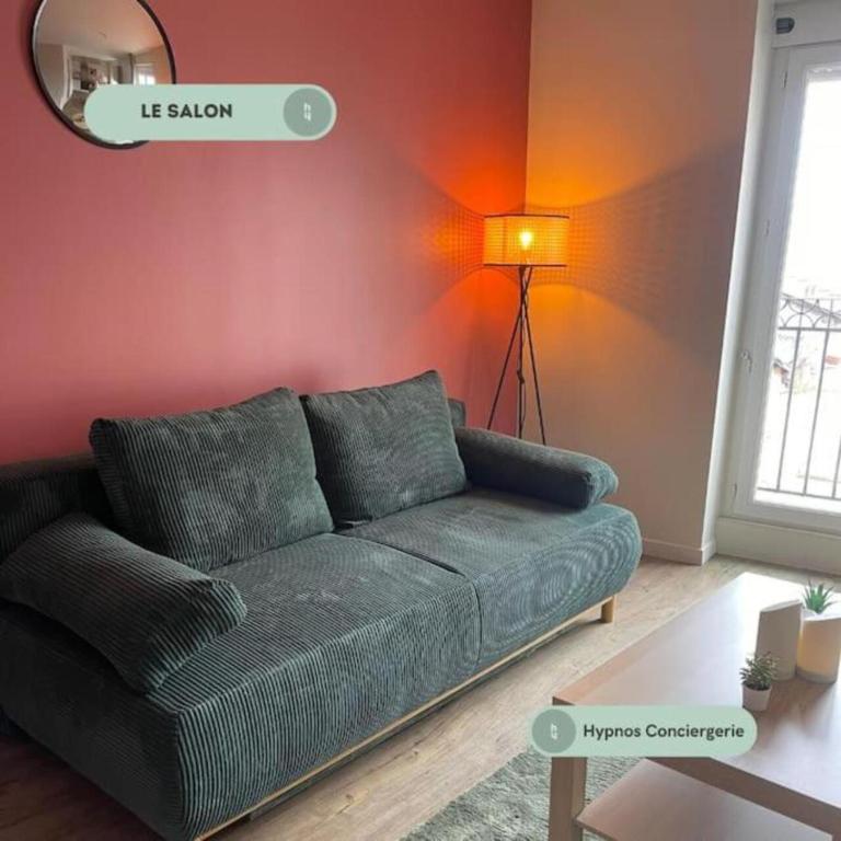 un salon avec un canapé vert et une lampe dans l'établissement Le capucin, départ Saint Jacques, au Puy-en-Velay