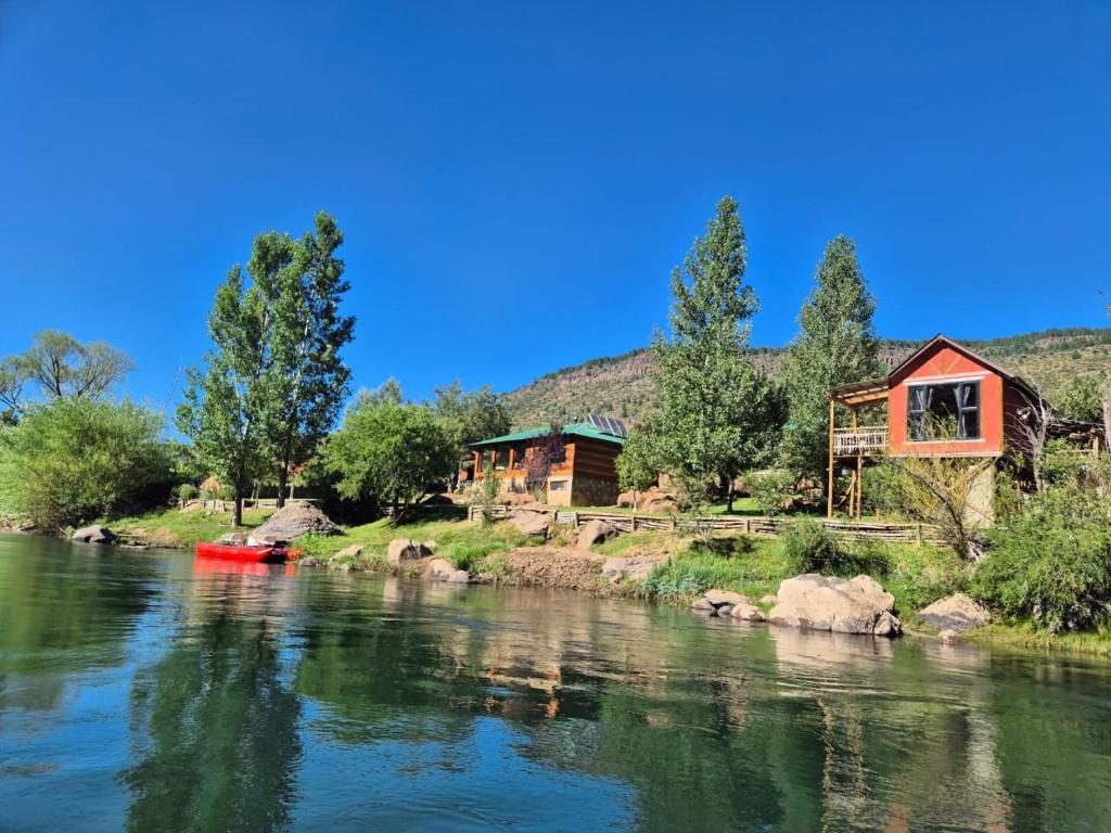 a house on the side of a river at Entre el Norte y el Sur in Aluminé