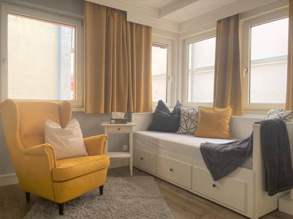 a room with a bed and a chair and windows at Ferienwohnung im Zentrum mit Balkon und Parkplatz in Gmunden