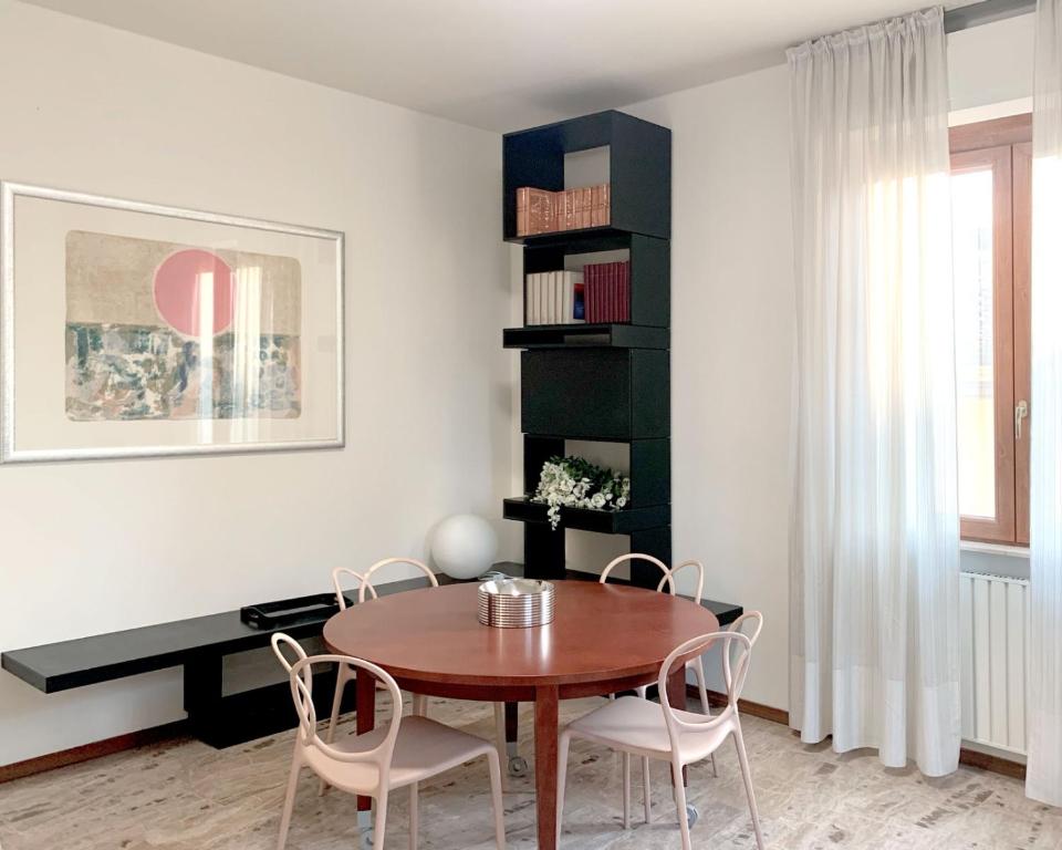 a dining room with a wooden table and chairs at Mini Suite Cremona in Cremona