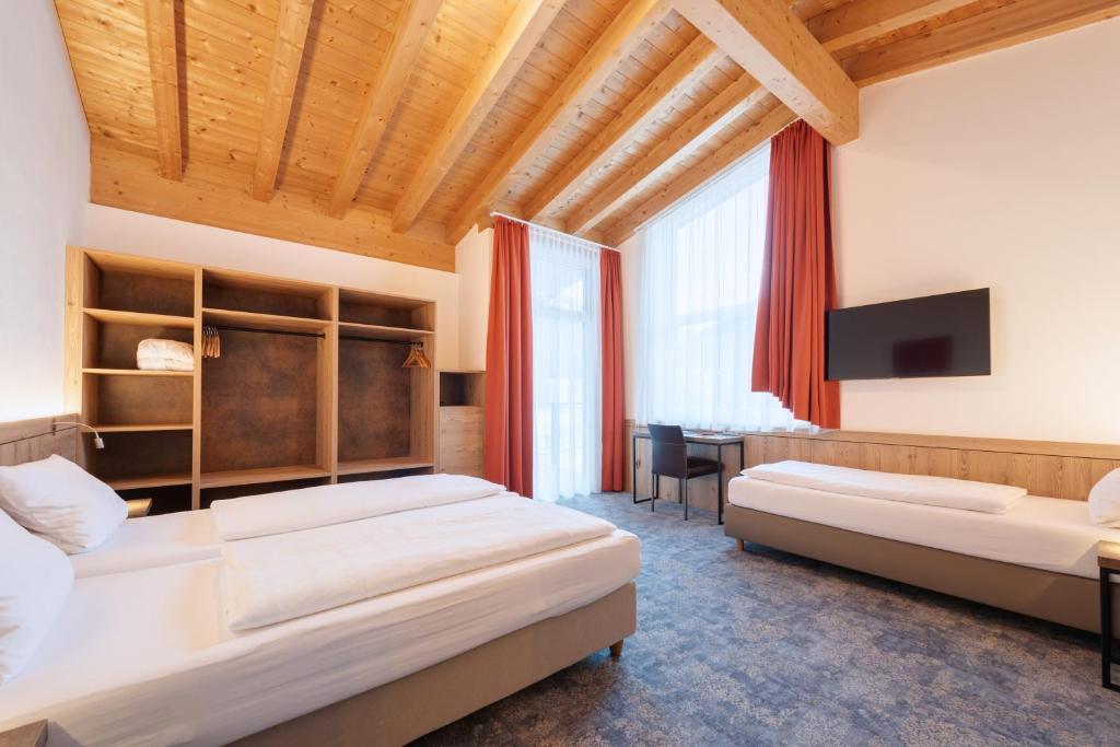Posteľ alebo postele v izbe v ubytovaní Hotel Alpenland