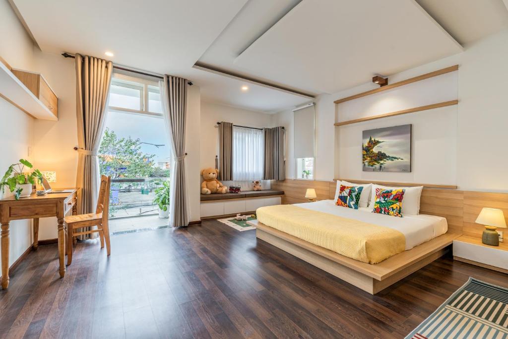ホイアンにあるHappy Villa Hoi Anのベッドとテーブルと机のある寝室