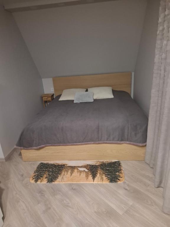 a bedroom with a bed and a rug on the floor at Šermukšnis in Rokiškis