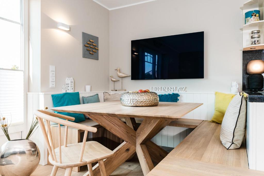 a dining room with a table and a tv at KÖ-Gartensuite in Westerland