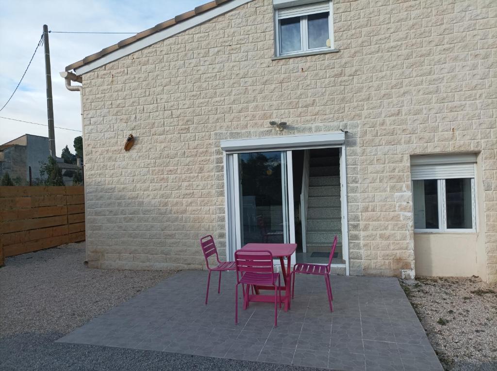 une table et des chaises violettes devant un bâtiment dans l'établissement Chez Sabine La campagne BIS, à Narbonne
