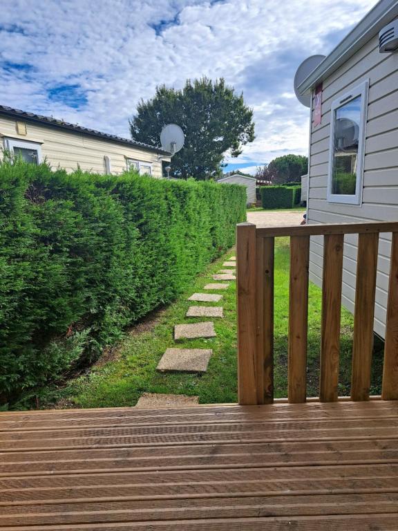 une terrasse en bois avec une clôture à côté d'une maison dans l'établissement D&S Cotttage, aux Mathes