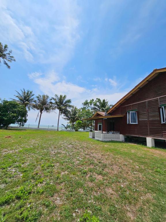 una casa con un prato accanto a un edificio di Balek Kualé a Kampong Baru