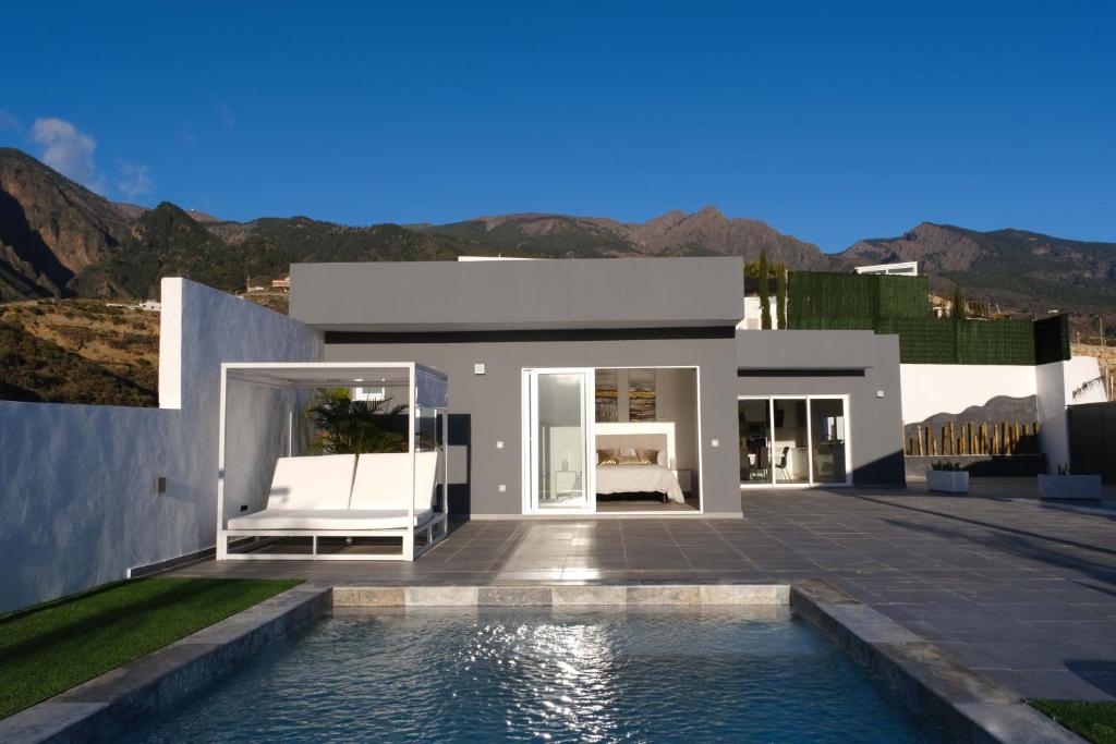 a villa with a swimming pool and mountains in the background at JVG VILLAS - Villa Giulia in Güimar