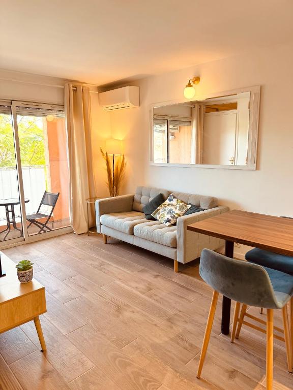 un salon avec un canapé et une table dans l'établissement Claelle Appartment - 200m beach, à Mandelieu-la-Napoule