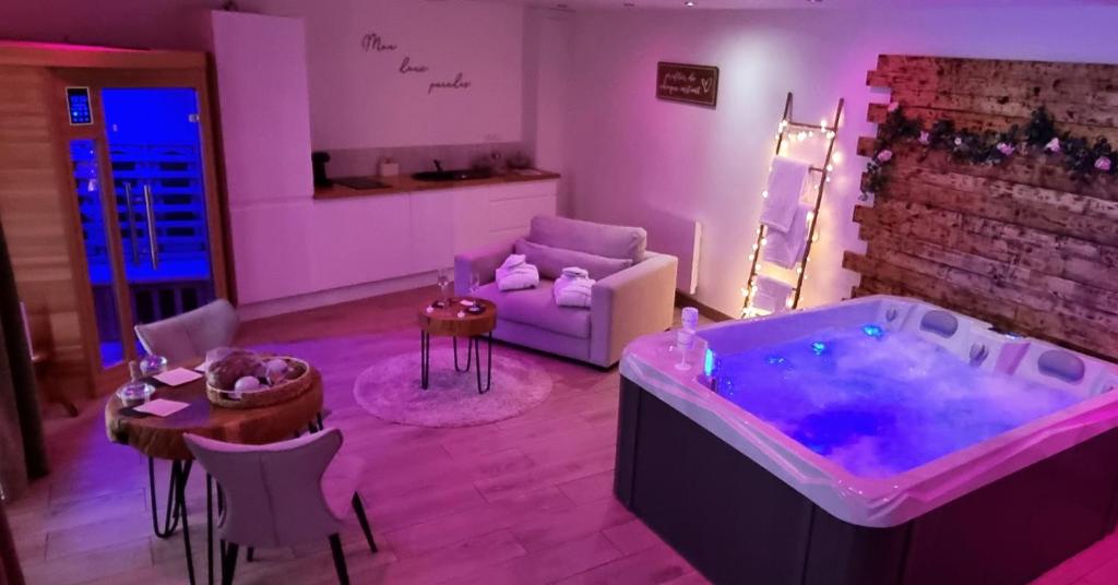 - un salon avec une baignoire et un canapé dans l'établissement Mon doux paradis, à Saint-Germain-la-Poterie