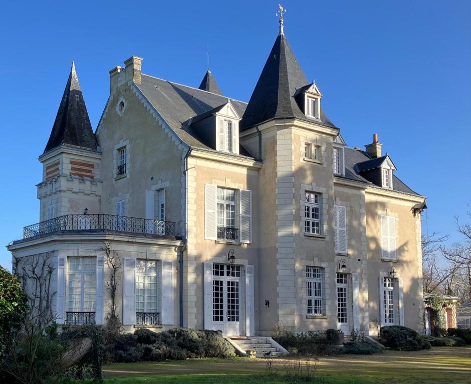 une grande maison blanche avec deux tourelles dans l'établissement Magnifique château au cœur de la Touraine, à Esvres