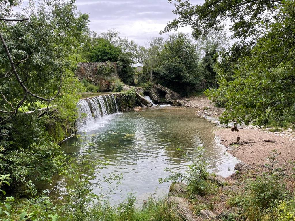 une cascade au milieu d'une rivière arborée dans l'établissement les Asphodèles 3 chambres, à Saint-Hippolyte-du-Fort