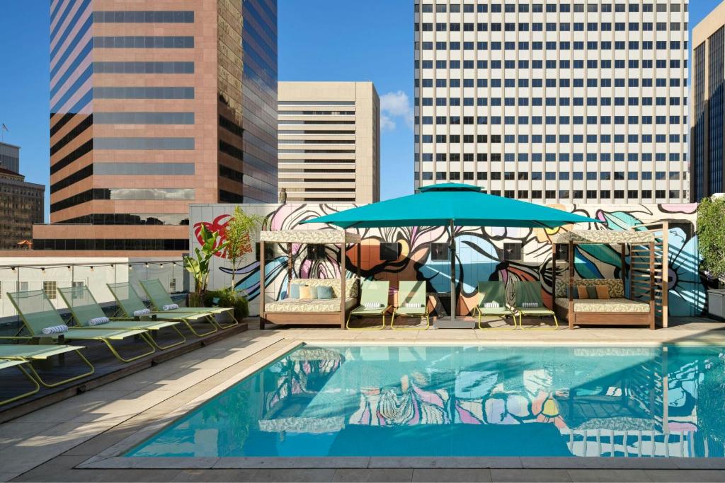 a pool with chairs and umbrellas on top of a building at Alma San Diego Downtown, a Tribute Portfolio Hotel in San Diego