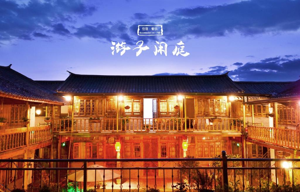 un edificio con un cartel en él por la noche en Tourist Courtyard Hotel, en Jianchuan