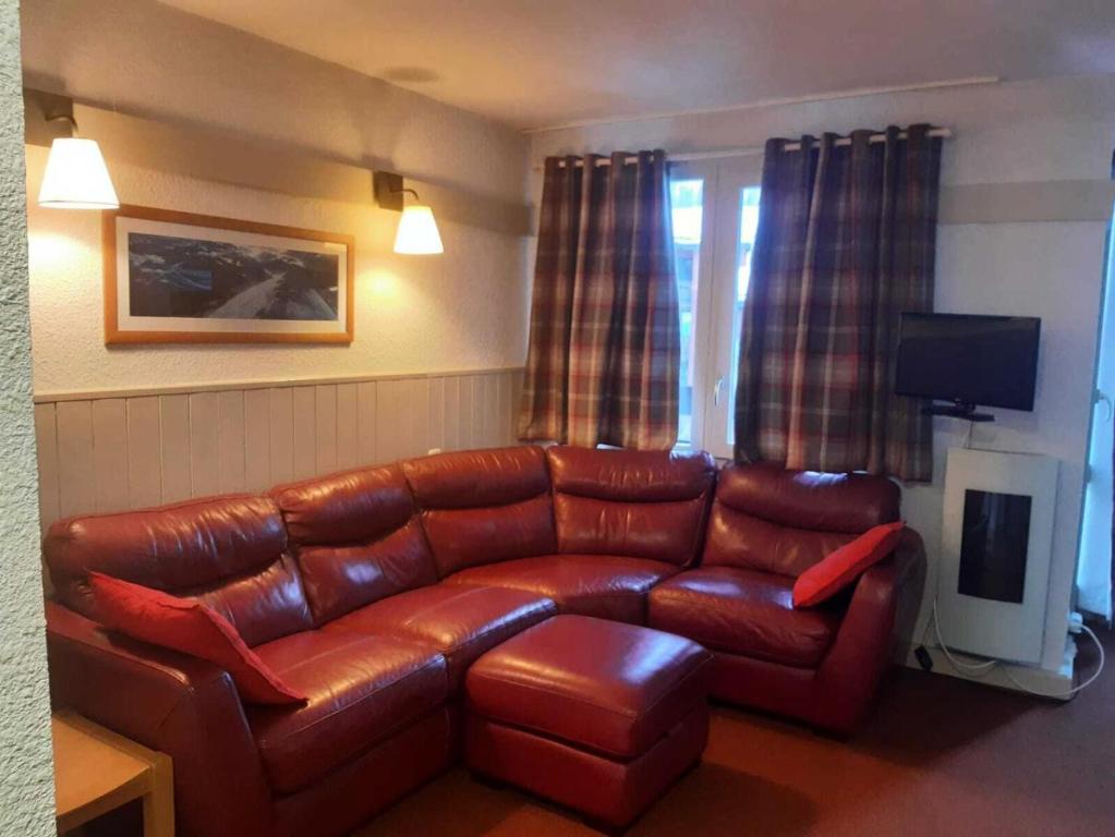 un salon avec un canapé en cuir et une télévision dans l'établissement Résidence Plagne Lauze - maeva Home - Appartement 2 pièces 5 personnes - Sélection MAE-2091, à Mâcot La Plagne