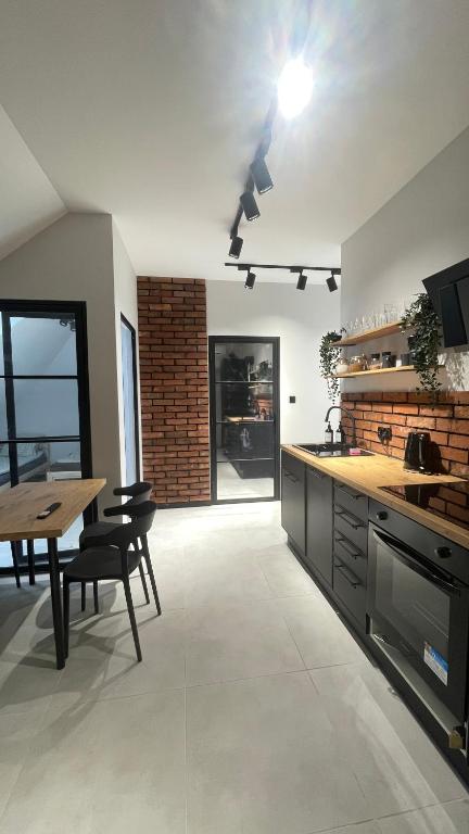 a kitchen with a wooden table and a dining room at Apartament Przytulny 7- Harmonia, self check in, parking in Rzeszów
