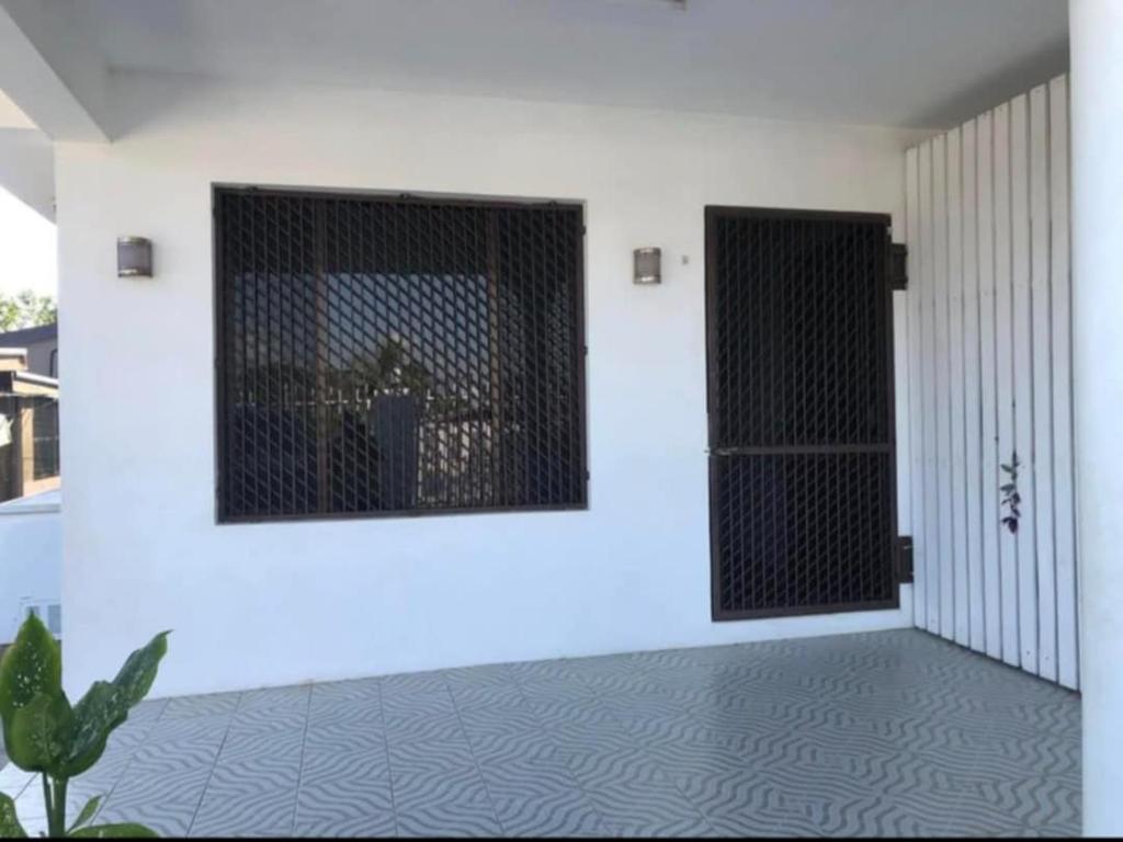 une pièce avec deux portes noires sur un mur blanc dans l'établissement bestwest apartments, à Nadi