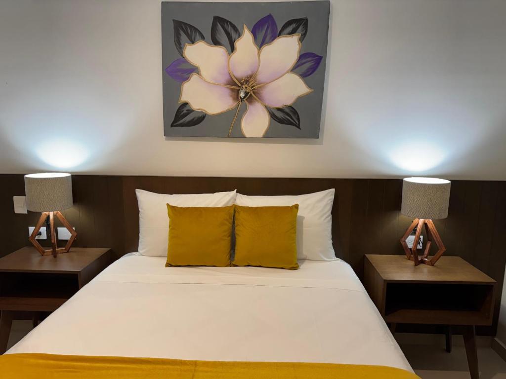 um quarto com uma cama com 2 candeeiros nas mesas em Hotel Faava em Mazatlán