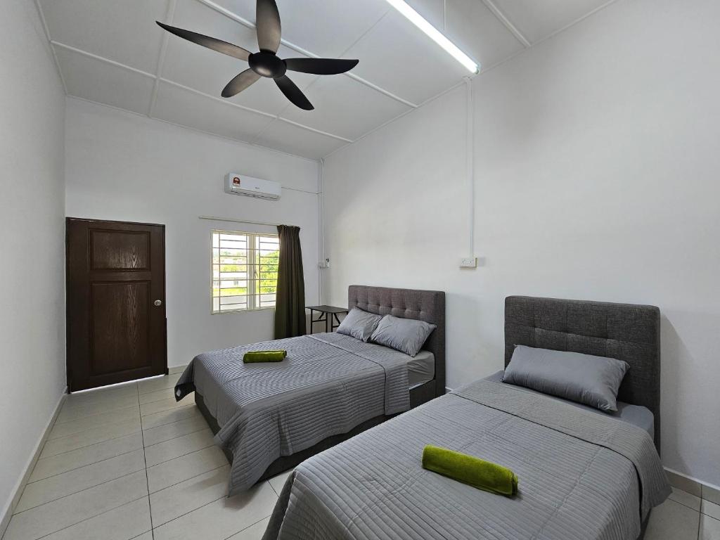 a bedroom with two beds and a ceiling fan at 1786 Guesthouse Seremban Homestay Sikamat小甘密 in Seremban