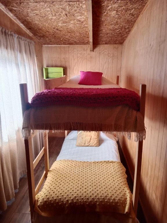 a bedroom with a bunk bed in a cabin at Rústica Futaleufú in Futaleufú