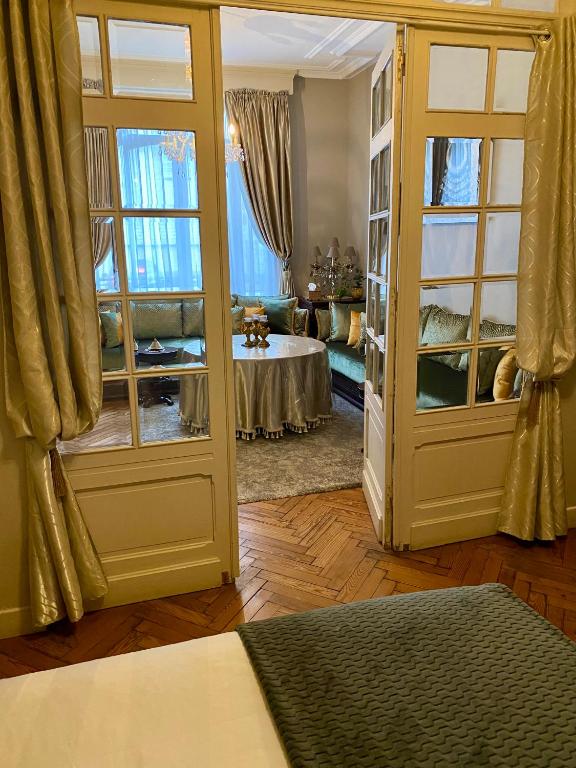 Cette chambre comprend un salon avec un canapé et des fenêtres. dans l'établissement A La Fleur d Oranger - Lille La Madeleine, à La Madeleine