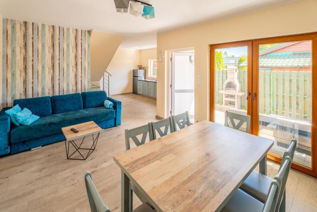 a living room with a blue couch and a table at Morski domek in Dębki