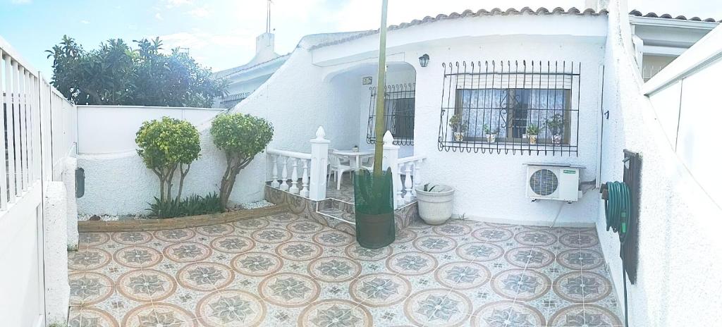 a white house with a tiled courtyard with a fence at El Rincón de Sotillo beach in Los Alcázares