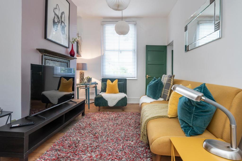 a living room with a couch and a tv at Chic 1-bed Garden Flat, London, Convenient for Tower Bridge, Great Public Transport in London