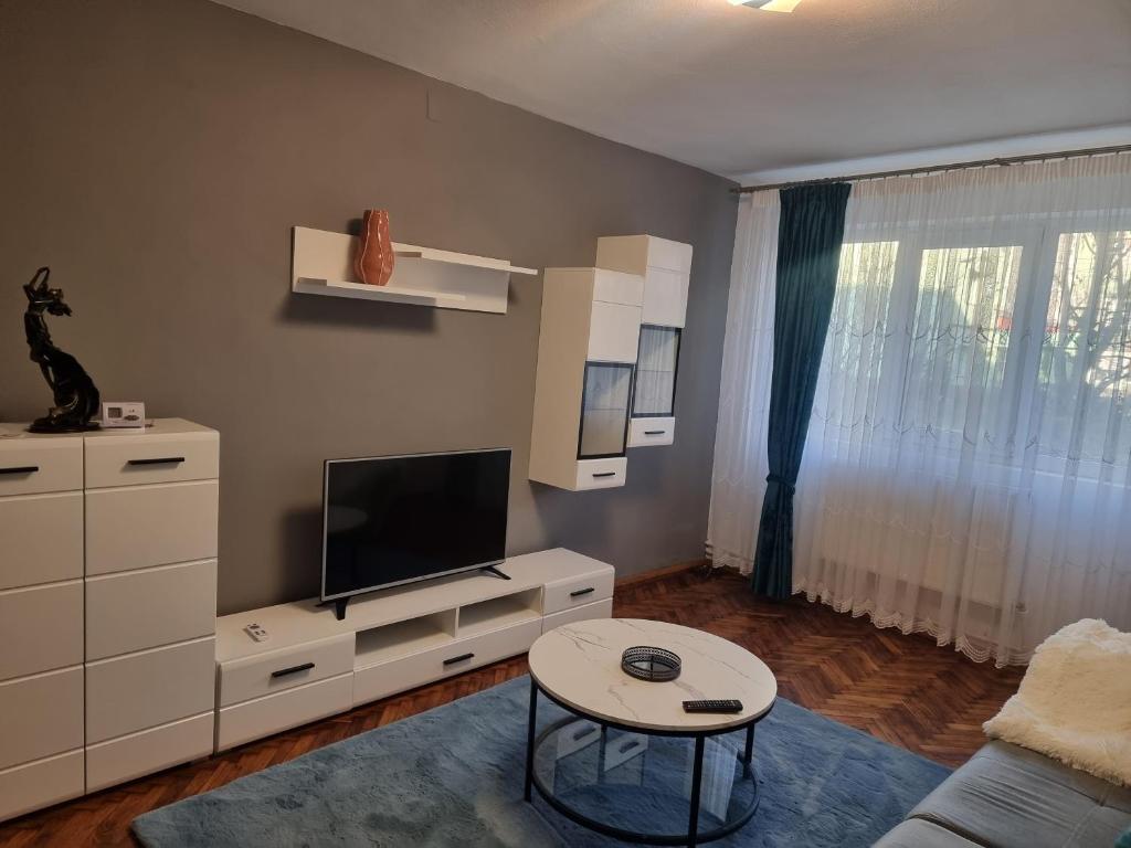 a living room with a tv and a table at 8 MAI Residence in Târgu Jiu