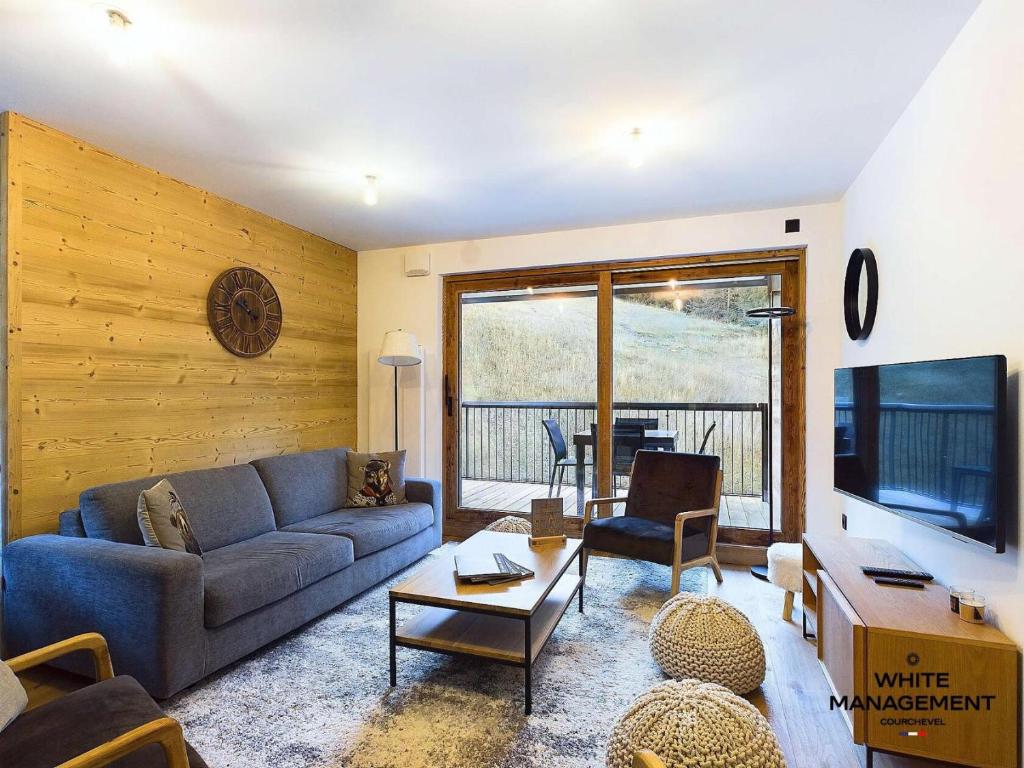 un salon avec un canapé et une télévision dans l'établissement Résidence Ariondaz Hellebore - Superbe appartement exposé Sud au pied des pistes MAE-2554, à Courchevel