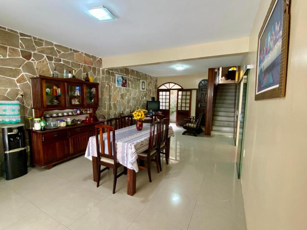 cocina con mesa, sillas y pared de piedra en Maravilhosa Residência perto da Cop, en Belém