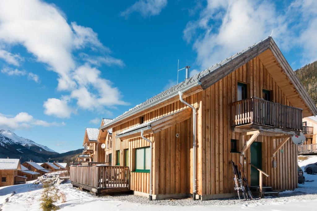 ein Blockhaus im Schnee mit blauem Himmel in der Unterkunft Chalet Triebenstein in Hohentauern