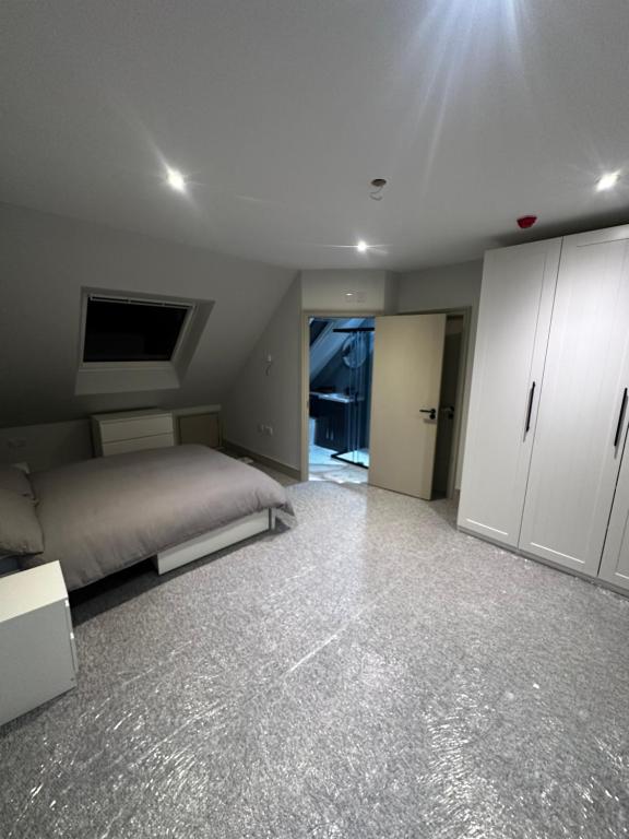 a bedroom with a bed and white cabinets at Abbey House in Waltham Abbey