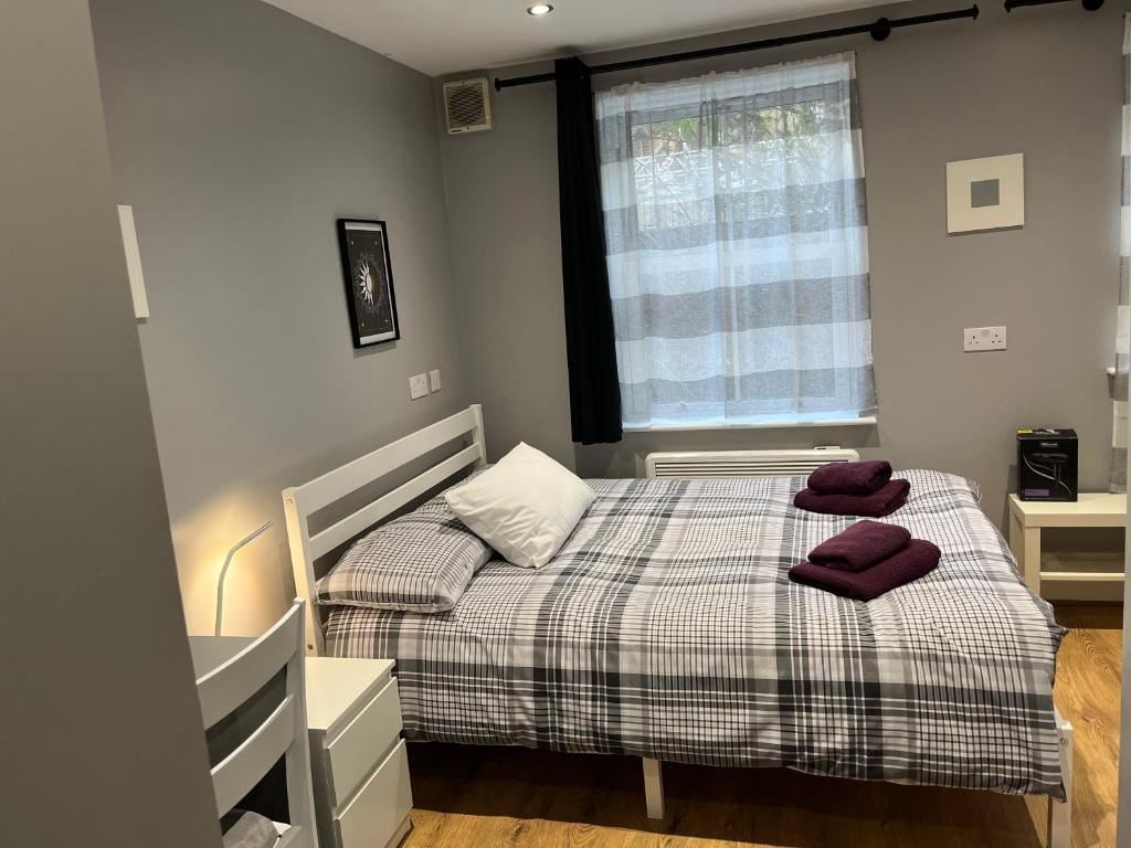 a bedroom with a bed with two towels on it at Cosy Rooms next to St Pancras Station in London