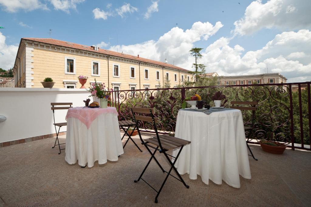 2 mesas con manteles blancos en un balcón en B&B Terrazza Flora en Campobasso