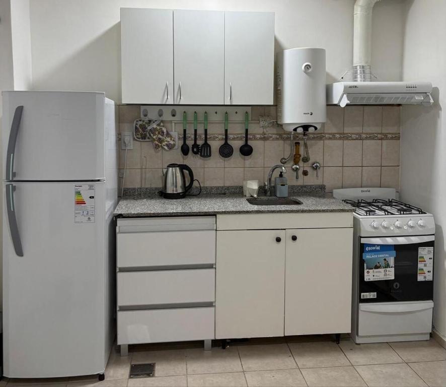 eine Küche mit weißen Schränken und einem weißen Kühlschrank in der Unterkunft Departamento moderno y luminoso in Barrio Rivadavia