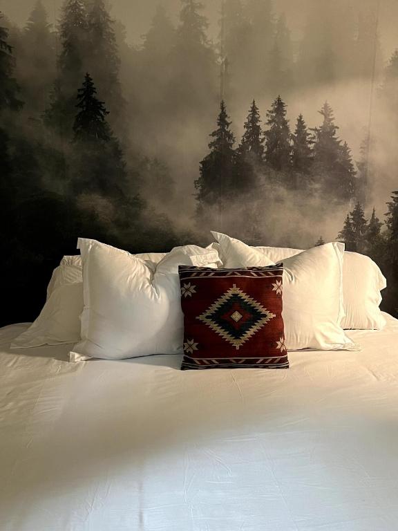 a white bed with white pillows and a painting at Moose Suite 1King Bed 1Queen Sofa bed + Hot Tub in Gatlinburg