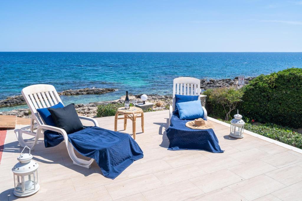 duas cadeiras sentadas num pátio perto do oceano em Prima Luce sul Mare em Fontane Bianche