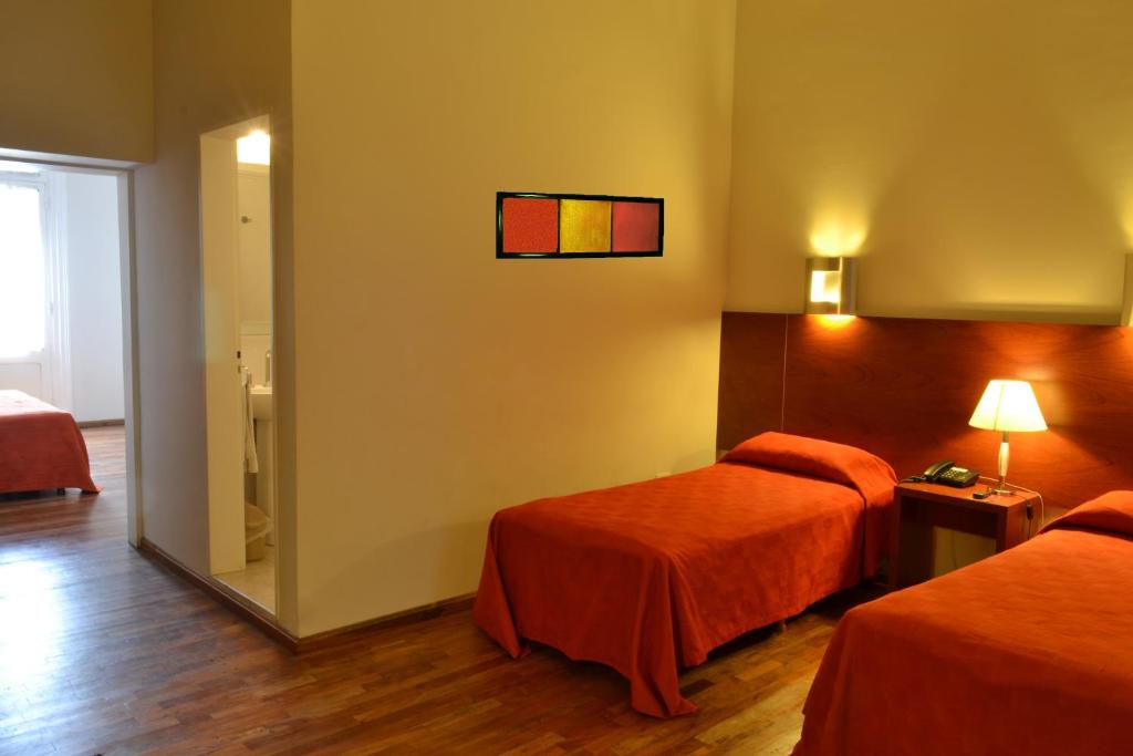 a hotel room with two beds and a window at Gran Hotel Victoria Cordoba Argentina in Córdoba