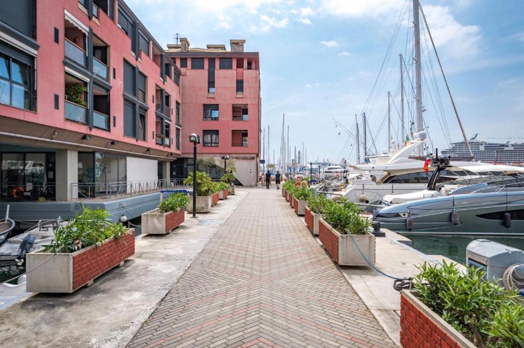 a walkway next to a marina with boats at APPARTAMENTO SUL MARE KATE in Genoa
