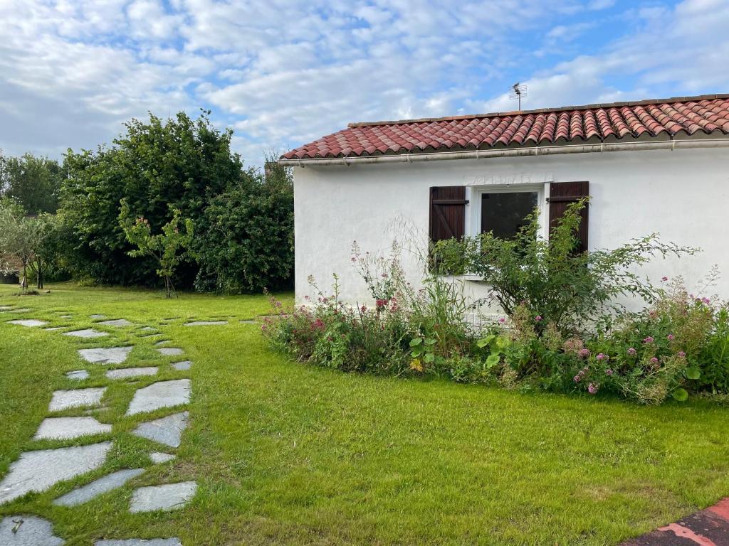 une petite maison blanche avec une cour gazonnée dans l'établissement Un studio indépendant avec jardin, à Talmont-Saint-Hilaire