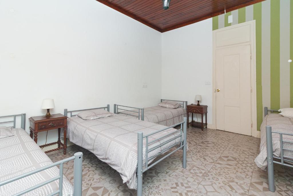two beds in a room with green and white walls at Guet House Vila tejo in Vila Franca de Xira
