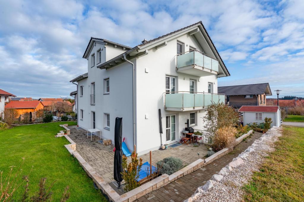 an exterior view of a white house with a yard at Ferienwohnungen Christoph in Pfaffing