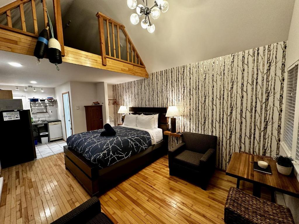 Un dormitorio con una cama y una sala de estar. en Cozy Cabin Centrally Located Close To Walking Trails And Beaches!, en Ucluelet