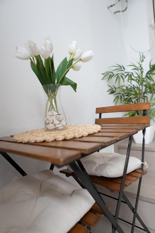 a table with a vase with white flowers on it at La casita de elle in Alora