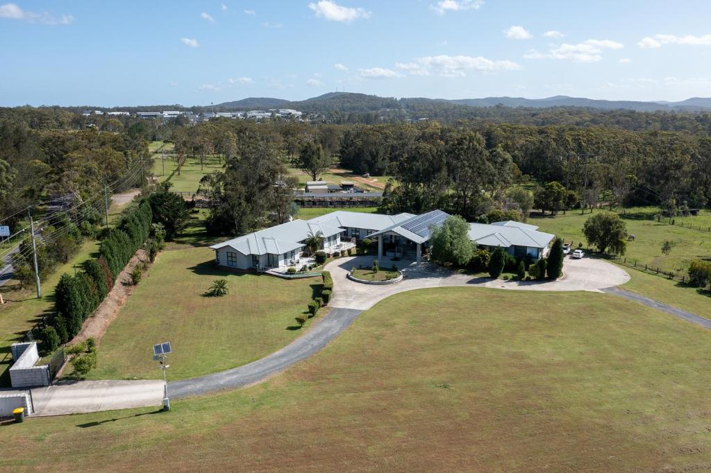 an aerial view of a house on a large grass field at Lake Macquarie Manor in Morisset
