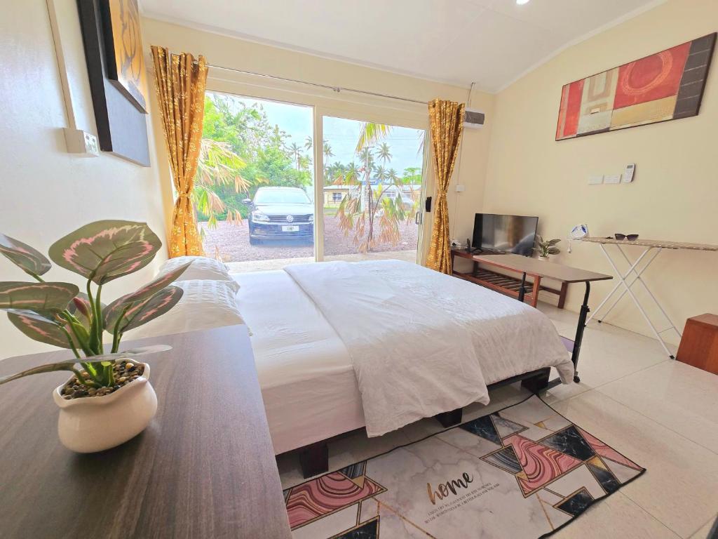 a bedroom with a bed and a potted plant at Seaside Exotic Studio in Suva City Quality bedding free wifi n parking in Suva